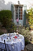 Set breakfast table in autumnal garden outside old country house with French windows