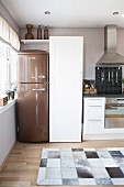 Kitchen in natural shades with bronze retro fridge and cowhide rug