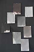 Colour-chart cards in various shades of grey hanging on wall