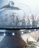 Glass nativity set on cake stand under glass cover