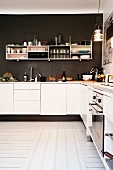 White fitted kitchen and shelves mounted on dark brown wall