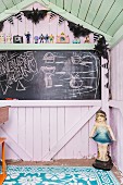 Chalkboard in pastel-coloured wooden play house