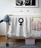 A knooked baby blanket with a female symbol – knitting with a hook