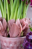 Dusky pink feathers decorating stems of flowers planted in retro flower pot