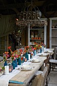 Rustic wooden table set with autumn flowers on roofed terrace
