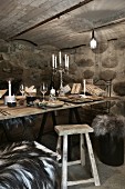 Weihnachten im Weinkeller: gedeckter rustikaler Holztisch mit Wein und Kerzen