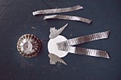 Engelsflügel, Metallförmchen & silbernes Geschenkband als Bastelutensilien