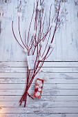 Schneeflocken aus Effektgarn gebastelt an roten Ästen hängend