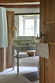 Sign hung on bathroom door and view of wash basin and pitcher on vintage table