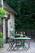 Metal garden furniture on terrace outside country house