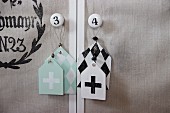 Shabby-chic tags with graphical patterns hanging from furniture knobs