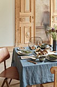 In provenzalischem Stil gedeckter Tisch mit blauer Leinentischdecke und duftenden Dekorationen