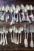 Silver cutlery lined up on rustic wooden table