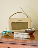 Jewellery in dish and clothes brush in front of retro portable radio