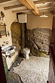 Partially rendered rock walls in Mediterranean bathroom