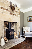 Log-burner in stone fireplace