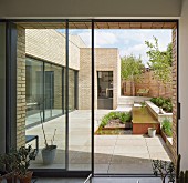 Blick auf geometrische Terrassengestaltung mit Pflanzbeet und Wasserbecken eines modernen Wohnhauses