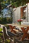 Rustic seating area in autumn sunshine outside wooden house