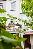 Zeitgenössischer Balkonanbau an renovierter Altbaufassade zur sommerlichen Gartenseite