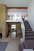 Galerie Treppenaufgang mit hellgrauem Teppichbelag in offenem Luxus-Wohnraum