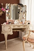 Jewellery, perfume bottles and cosmetics on dressing table in ornate Rococo style