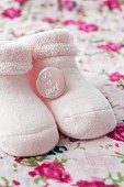 Pink baby socks with a badge