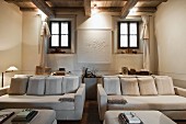 Elegante, weiße Sofagarnitur mit passenden Couchtischen in renoviertem, rustikalem Wohnzimmer