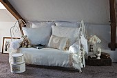Vintage-style lace cushions on white metal couch with ornate frame