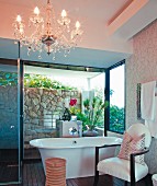 Armchair, stool and chandelier in cosy bathroom