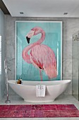 Picture of flamingo on wall above free-standing bathtub in marble bathroom