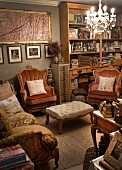 Antique-style sofa and armchairs around ottoman below chandelier in living room