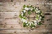 Wreath of snowberries on rustic wooden surface