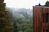 Modernes Wohnhaus aus Holz in bewaldeter Landschaft