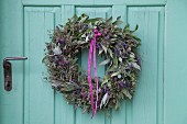Wreath of lavender and sage hung on turquoise wooden door