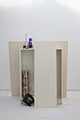 White cabinet, cordless jigsaw, roll of wallpaper, scissors and tools