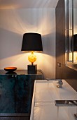 Weisser Designer-Doppelwaschtisch und künstlerische Tischleuchte mit schwarzem Lampenschirm auf edlem Sideboard