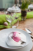 Place setting with purple Easter egg in napkin nest