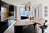 Semicircular counter with marble worksurface in black glossy kitchen