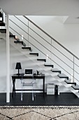 Schreibtisch mit Ghoststuhl unter Treppenlauf in zeitgenössischem Treppenhaus