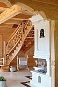 Custom staircase with carved balustrade and wood-burning oven in solid wooden house