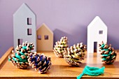 Pine cones wrapped with colourful thread and house-shaped ornaments