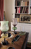 Vintage glass paraffin lamps on antique desk in front of white bookcase
