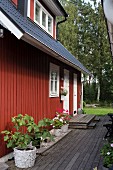 Rotes Schwedenhaus mit Terrasse im Sommer