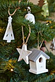 White-painted wooden Christmas decorations hanging on Christmas tree