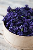 Dried mallow flowers (Malva sylvestris) in a wooden bowl