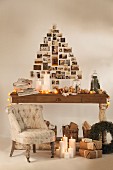 Weihnachtlich dekorierter Holztisch und Weihnachtsgeschenke am Boden, an Wand Weihnachtsbaumform aus nostalgischen Fotos