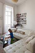 Girl playing in front of white leather sofas in living room