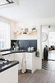 Kitchen with white polygonal counters and black worksurface