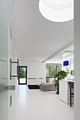Open-plan interior with white floor and skylight