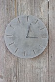 Hand-made concrete clock on board wall